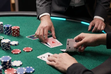 Live-Blackjack-Tisch mit Dealer-H&auml;nden und Karten auf gr&uuml;nem Filz - blackjack spielen im live casino online bei OnlySpins